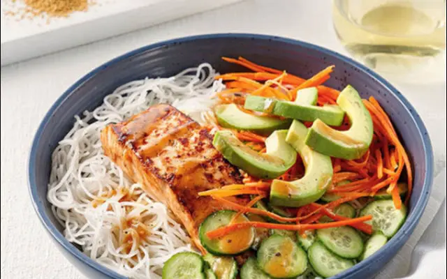 Bol de vermicelles au saumon, avocat et légumes croquants servi au déjeuner